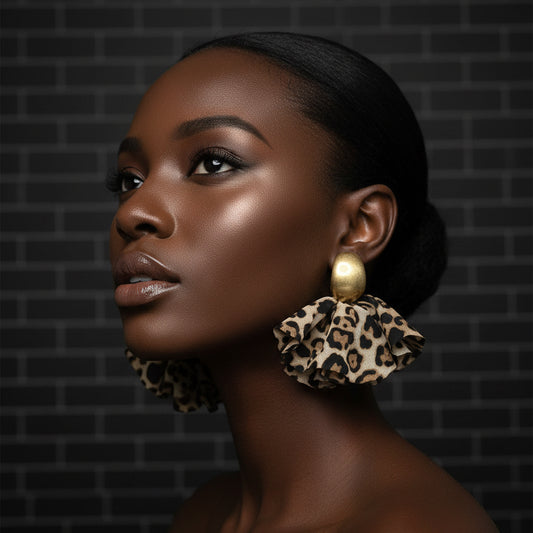 Woman wearing large, leopard print ornate earrings against a dark brick wall.