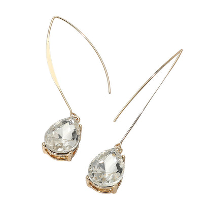 Pair of gold earrings with clear gemstones on a white background