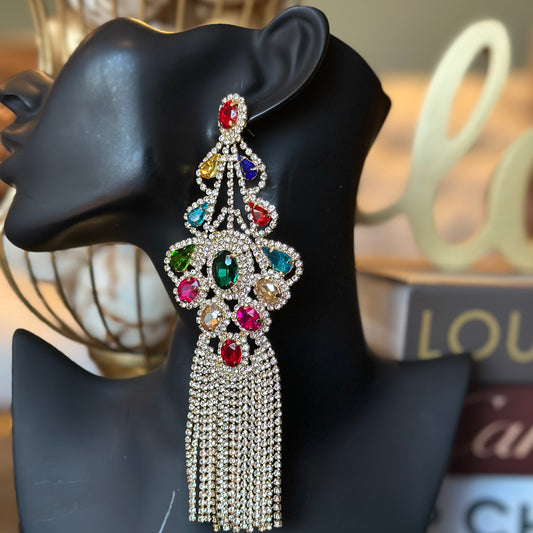 Decorative earring with colorful gemstones on a black mannequin head.