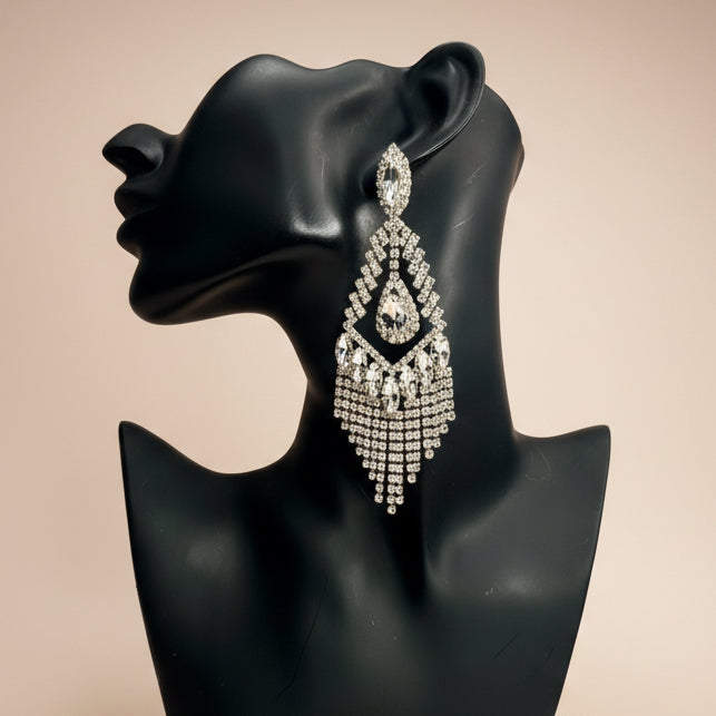 Diamond gold fringe earring on a black mannequin bust against a beige  background
