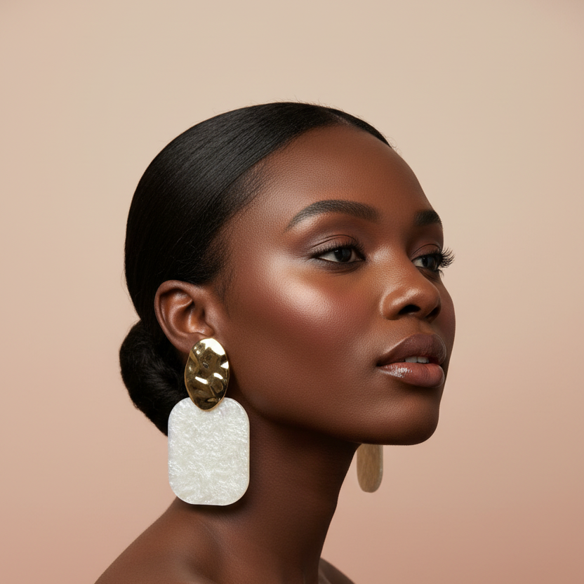 Woman wearing large, ornate earrings against a beige background
