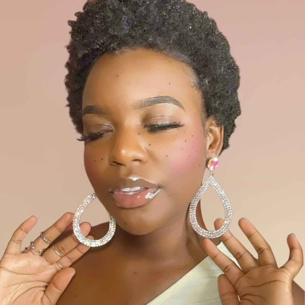 Woman wearing large teardrop earrings against a beige background