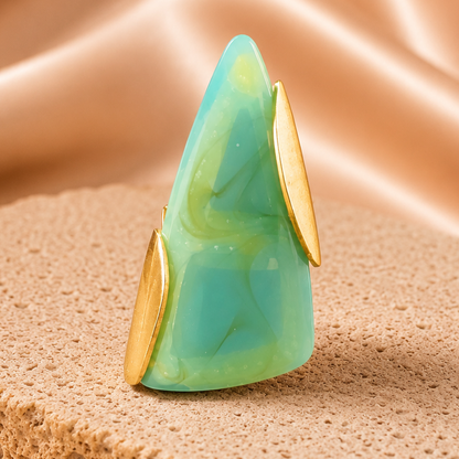 Turquoise stone ring with gold accents on a beige fabric background