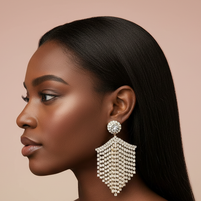 Woman wearing a large, ornate rhinestone earring against a beige background