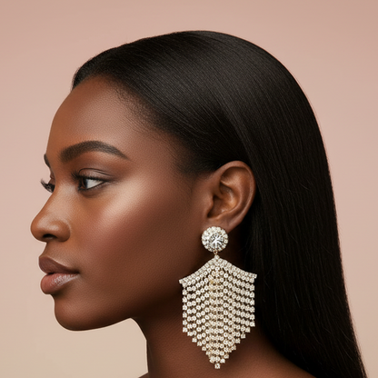 Woman wearing a large, ornate rhinestone earring against a beige background